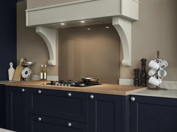 Dark navy kitchen with wooden countertop, cream range hood, and neutral tiled backsplash.