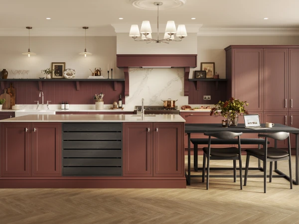 Modern kitchen showroom display with burgundy cabinetry, marble backsplash, and dining table seating area.
