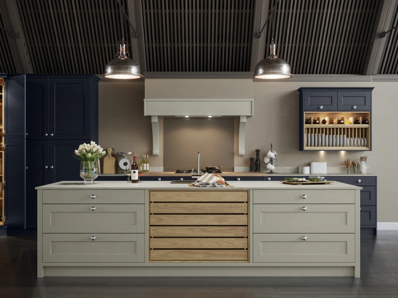 Modern kitchen showroom display with navy and sage cabinetry, central island with wooden drawers, and pendant lighting.