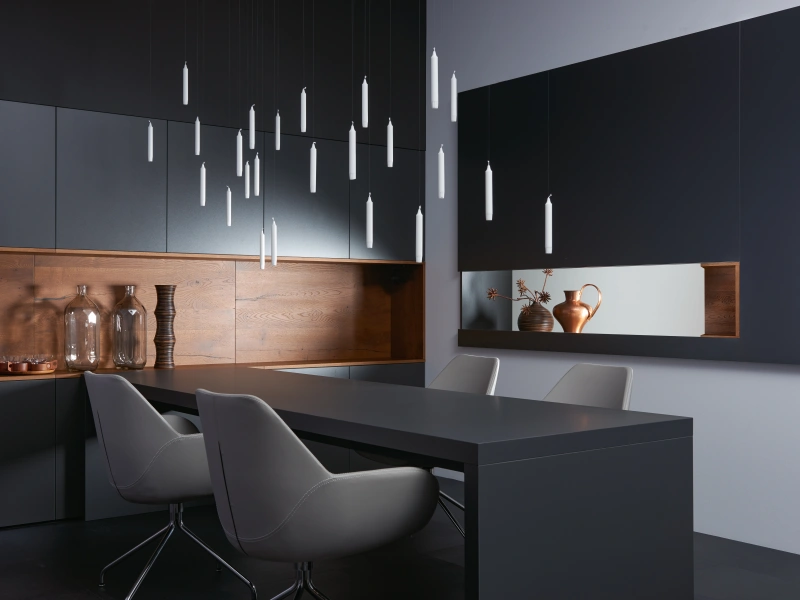 Modern kitchen with dark cabinetry, wood accents, pendant lights, and island seating.