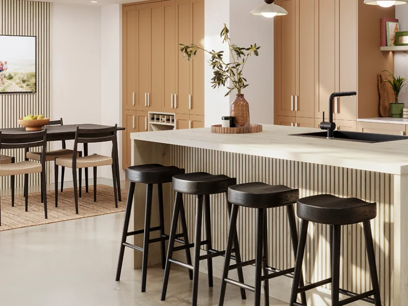Modern kitchen with natural wood cabinetry, white countertop island, black bar stools, and pendant lighting.