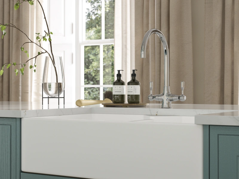 Modern kitchen sink with teal cabinetry, white countertop, and large window with neutral curtains.