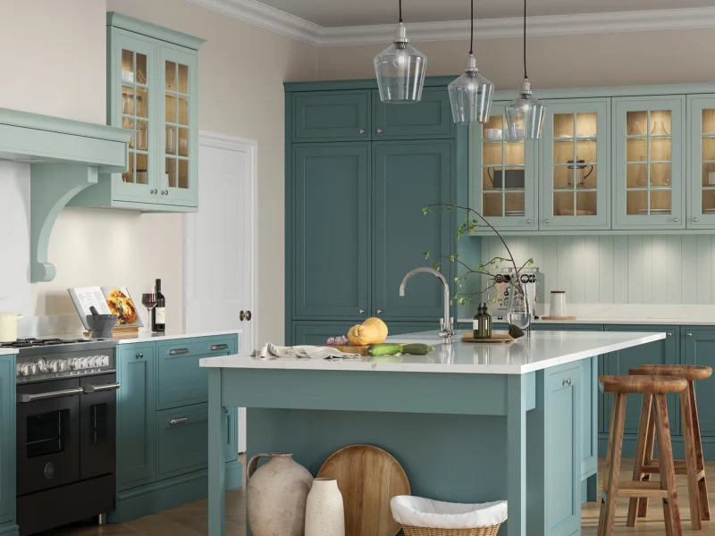 Modern kitchen with sage green cabinetry, white marble countertops, and glass-fronted upper cabinets, featuring a central island with white countertop and wooden bar stools, pendant lights, arched range hood, and natural light from archway window