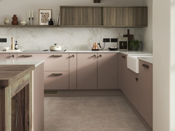 Modern kitchen showroom display with pink cabinetry, marble backsplash, and wood accents.