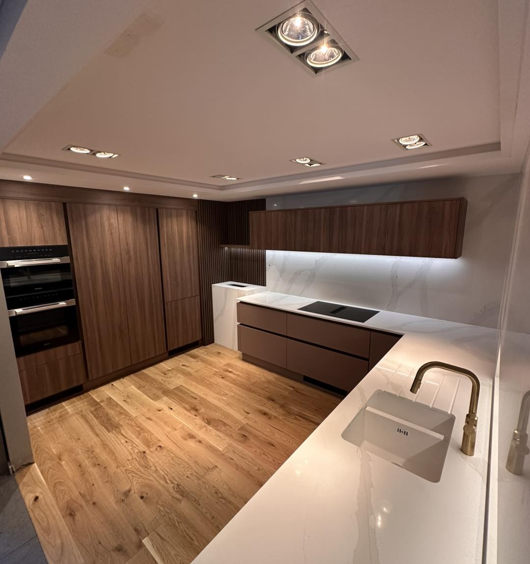 Walnut kitchen with white quartz worktop and brass tap